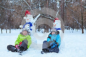 Fun, happy kids playing with snowman