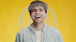 Fun and humor. Close up portrait of young happy carefree guy laughing loudly, enjoying joke, expressing positivity