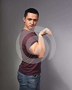 Fun humor grimacing young man showing crazy duck pose on grey background