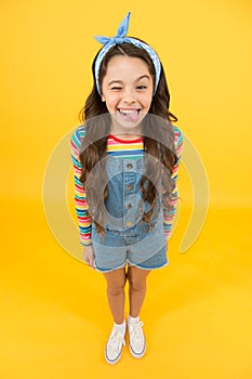 Fun lifestyle little girl long hair denim overalls, cheerful grimace concept