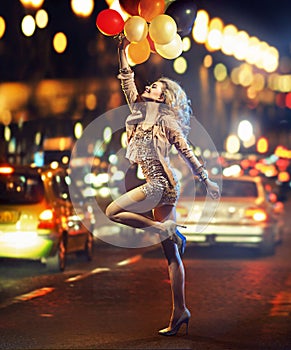 Fun-loving girl holding a bunch of balloons