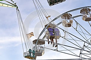 Fun in the lunapark, people on the rollercoaster and big wheel