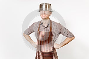 Fun man in striped apron with silver stainless glossy aluminium empty stewpan, pan or pot on head isolated on white