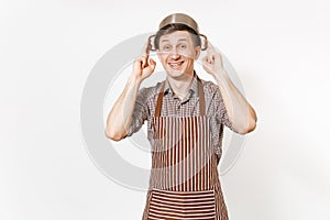 Fun man in striped apron with silver stainless glossy aluminium empty stewpan, pan or pot on head isolated on white