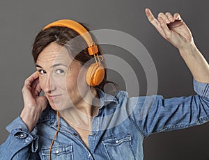 Fun middle aged woman listening to music for joyous wellbeing