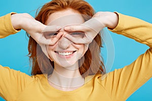 Fun and People Concept - Headshot Portrait of happy ginger red hair girl with freckles smiling and making finger glasses