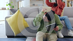 Fun, pillow fight and couple in a living room happy, playing and bonding in their home. Cushion, battle and man with