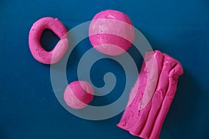 Fun plasticine texture painted on a modeling board. Toying with pink plasticine. Consists of the plasticine. Modeling figure. Lett