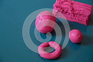 Fun plasticine texture painted on a modeling board. Toying with pink plasticine. Consists of the plasticine. Modeling figure. Lett photo