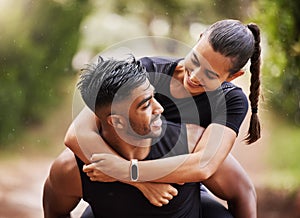 Fun and playful couple playing on a hike in nature, giving piggyback and enjoying a walk in the outdoors together. Happy