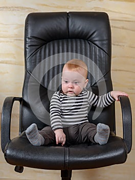 Fun portrait of a cute boy in an office chair