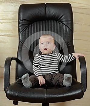 Fun portrait of a cute boy in an office chair