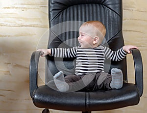 Fun portrait of a cute boy in an office chair