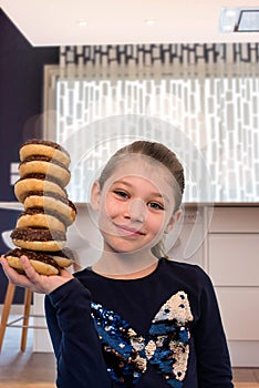 fun portrait of a smiling girl with her stack of donuts in balance
