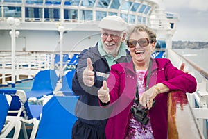 Fun Senior Couple Give a Thumbs Up on Deck of Cruise Ship