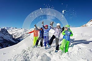 Fun ski children group over mountain throw snow up