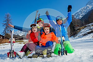 Fun on ski vacation mother and kids sit in snow with skies