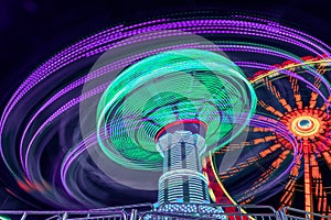 Fun for teens and family. A long exposure of a amusement park with a chain carusel in a very dynamic rotation in the