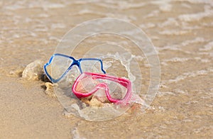 Fun water activity. two diving masks at the beach splashed by wa