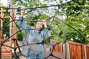 Fun woman in an adventure rope park at children playground