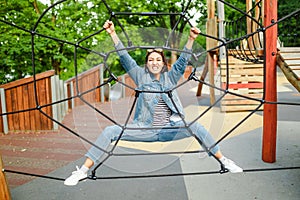 Fun woman in an adventure rope park at children playground