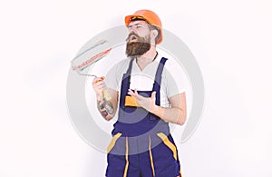 Fun at work. Builder holding paint roller as microphone. Young man singing lyric song over white background