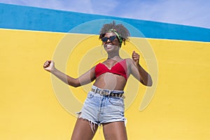 Fun young afro american woman laughing with arms raised