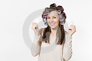 Fun young woman with curlers wipes her skin face with facial sponges isolated on white background. Crazy makeup with set