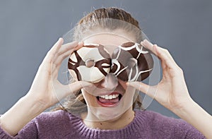 Fun young woman hiding eyes for disgust of fat sweets