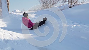 Fun Young woman snow tube in winter park. Leisure on nature, snow slide skiing. Concept of interactive entertainment