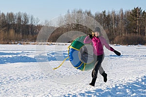 Fun Young woman with snow tubing winter activity, runs in winter. Winter entertainment