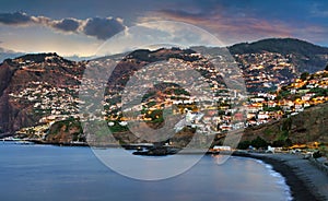 Funchal city at night in Madeira near black Formosa beach, Portugal