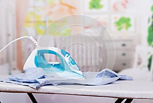 Functional modern iron on the Ironing Board on light background