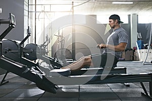 Functional Training. Man Doing Exercise On Rowing Machine At Gym