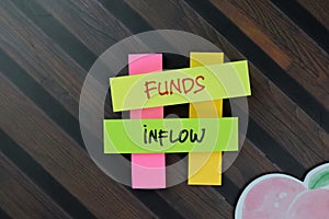 Funds Inflow write on sticky notes isolated on Wooden Table photo