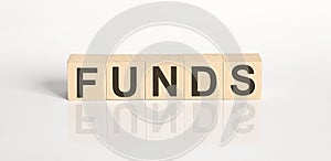 FUNDS word from wooden blocks on the white desk