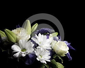 Funeral Bouquet purple White flowers, Sympathy and Condolence Concept on blackbackground with copy space