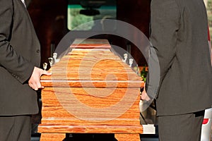 Funeral with casket carried by coffin bearer