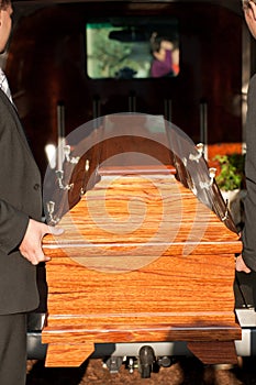 Funeral with casket carried by coffin bearer