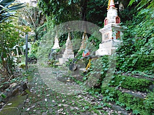Funeral chedis are set up beside a footpath at a Thai temple