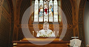 Funeral, church and priest with prayer by coffin for memorial service, sermon and ceremony for death. Religion, guidance