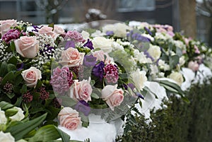 Funeral flowers arrangement in the snow on a cemetery photo