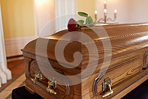 Red rose flower on wooden coffin in church photo