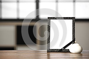 Funeral photo frame with black ribbon and candle on table indoors. Space for design