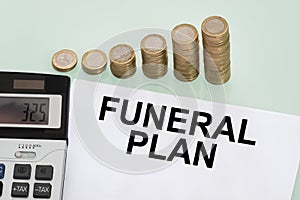 Funeral Plan Papers, Stack Of Coins And Calculator Over Desk