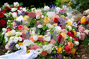 funeral wreath with white ribbon and many colourful flowers