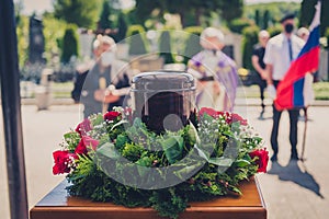 Funerary urn with ashes of dead and flowers at funeral