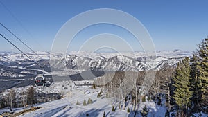 Funicular over a snowy valley. The booths are visible on the ropes