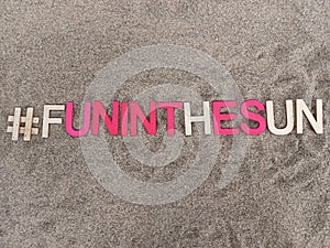 #funinthesun fun in the sun written on sand at the beach