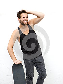 Funky guy holding skateboard against white background